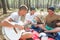 Cheerful youth plays guitar in camp in nature