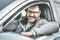 Cheerfully young man in car.