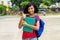 Cheering hispanic female college student with backpack