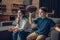 Cheering little boy and his mother sitting on couch with rugby ball while watching game