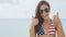 Cheering woman joyful doing fun thumbs up with USA flag bikini on american beach