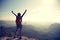 Cheering young traveler with backpack on the mountain peak