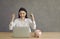 Cheering young woman sitting at desk with piggybank front of laptop screen