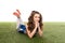 Cheerleader girl in blue uniform lying on green field  on white