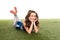 Cheerleader girl in blue uniform lying on green field  on white