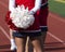 Cheerleader with pom pom behind her