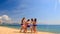 Cheerleaders from backside perform Basket Toss on sand