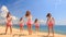 cheerleaders dance show varied poses on beach against sea