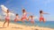 Cheerleaders dance squat show poses on beach against sea