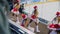 Cheerleaders in Santa caps dance near ice rink backside view