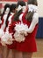 Cheerleaders standing with their pom poms behind them at a basketball game