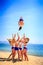 Cheerleaders in white blue perform Back Tuck Basket Toss on beach