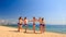 Cheerleaders in white blue perform Swedish falls on beach