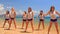 cheerleaders in white blue run out of water dance on beach
