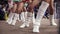 Cheerleaders in white leg sleeves dance near hockey rink