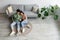 Cheery Asian couple using smartphone application, relaxing on sofa at home on weekend, top view. Copy space