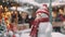 Cheery snowman wearing a festive red hat and scarf at a snowy Christmas market, copy space. AI generated