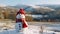 Cheery snowman wearing a festive red hat and scarf at a snowy landscape, copy space. AI generated