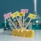 A chees decorated with name plates of additives E, test tubes stand nearby. Food laboratory. Close up on a white table