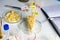 A chees decorated with name plates of additives E, test tubes stand nearby. Food laboratory. Close up on a white table.