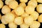 Cheese balls snack isolated over black background. Pile of cheese flavored crunchy puffed balls isolated. Close up