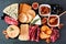 Cheese board with a selection of cheeses and meats, top view on a dark background