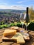 Cheese board and white wine against the backdrop of village. AI