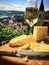 Cheese board and white wine against the backdrop of village. AI