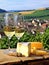 Cheese board and white wine against the backdrop of village. AI