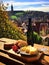 Cheese board and white wine against the backdrop of village. AI