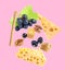 Cheese, breadstick, grapes and walnut falling against pale pink background