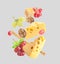 Cheese, breadstick, grapes and walnuts falling against light grey background