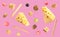 Cheese, breadsticks, grapes and walnuts falling against pink background