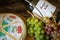 Cheese Brie with bottle of Chardonnay of Casillero del Diablo with bunch of grapes on the table