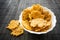 Cheese Chips Snack in a round white bowl on a black wooden background. Grain Free Dippable Crispy Cheddar Cheese Chips, Keto & Lo