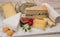 Cheese collection, marble board with French cheeses brie, tomme, matured goat cheese, morbier  served with fresh raspberries and