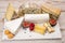 Cheese collection, marble board with French cheeses brie, tomme, matured goat cheese, morbier served with fresh raspberries and