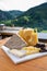 Cheese collection, Swiss cow cheese emmental, tomme and dark chocolate and mountains village in Apls on background