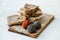 Cheese composition with wood board and bread. Dried goat`s cheese in balls with pepper. Craft food