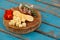 Cheese cubes, capsicum, meat, rosemary and biscuits on wooden board