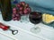 Cheese, glasses and bottle of red wine placed on wooden table, copyspace for text.