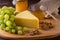 Cheese with grapes, olive, honey on wood