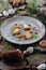 Cheese Harmony: Gray Plate Amidst New Year\\\'s Greenery and Nuts