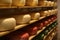 Cheese heads on shelves in factory warehouse