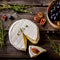 Cheese, herbs, nuts and grape on dark wooden table.