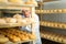 Cheese maker brushing mould off the hard cheeses by hand. Numbers on white pieces of paper are date when cheese was put