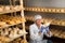 Cheese maker brushing mould off the hard cheeses by hand. Numbers on white pieces of paper are date when cheese was put