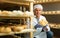 Cheese maker brushing mould off the hard cheeses by hand. Numbers on white pieces of paper are date when cheese was put