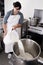 Cheese Maker pours milk into a steel container