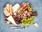 Cheese and meat appetizer selection or wine snack set. Variety of cheese, salami, prosciutto, bread sticks, baguette, honey, grap